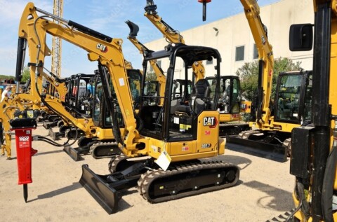 Wiele minikoparek CAT ustawionych w rzędzie.