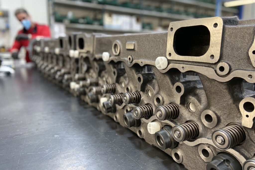 Zbliżenie na rząd głowic cylindrów silnika w procesie montażu w fabryce.