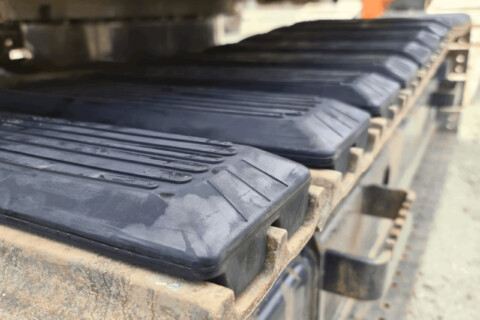 Gumové kryty na pásech stavebního stroje.