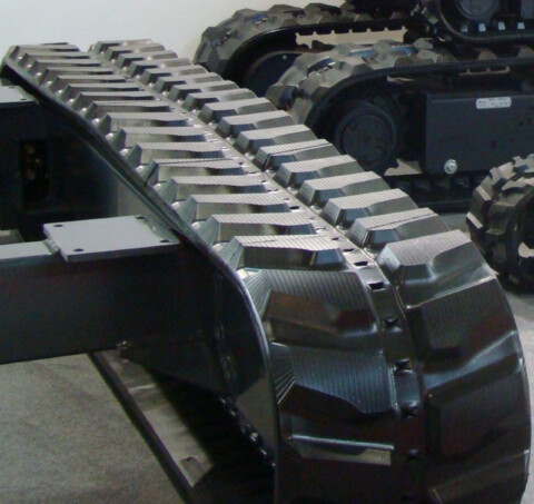 Detailní záběr na pásové podvozek stroje.