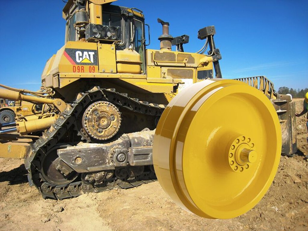 Buldozer značky CAT model D9R 09 s viditelným detailem pásového podvozku.