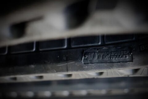 Obrázek zobrazuje detail gumového pásu s nápisem „ITR Rubber Tracks“.