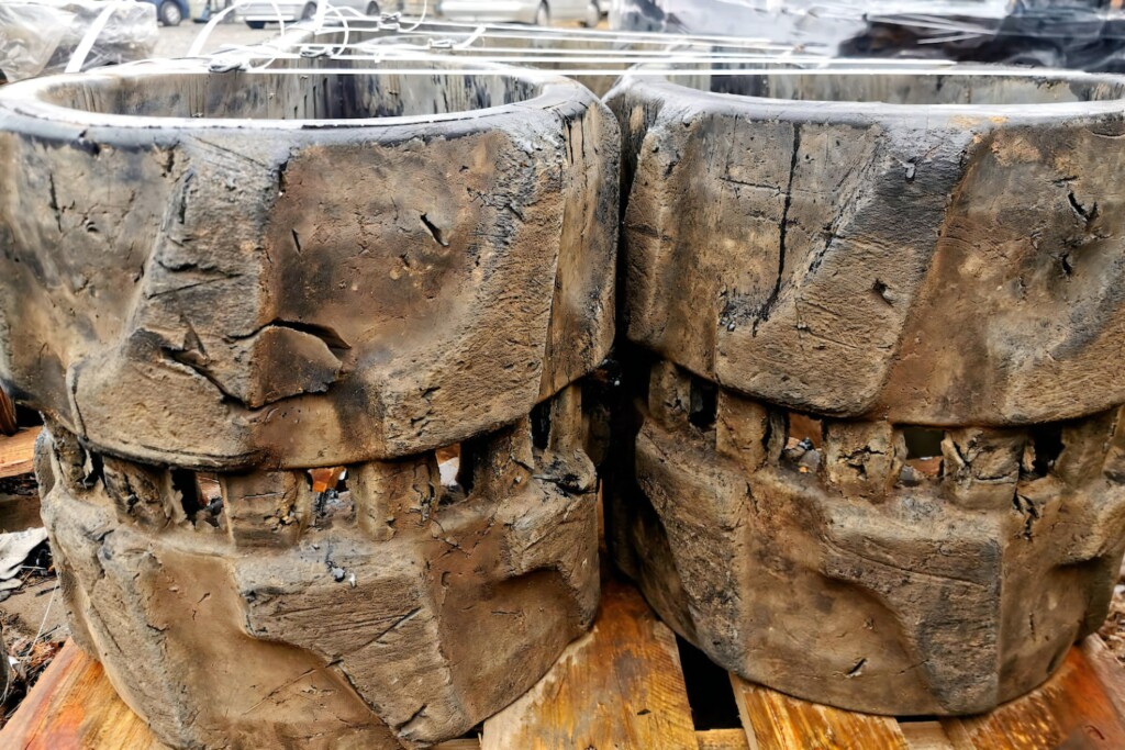 Detailní záběr na silně opotřebené gumové pásy s viditelnými hlubokými prasklinami a chybějícími částmi.