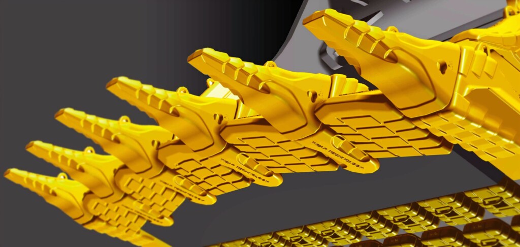 Žluté kovové zuby stavebního stroje na detailním záběru.