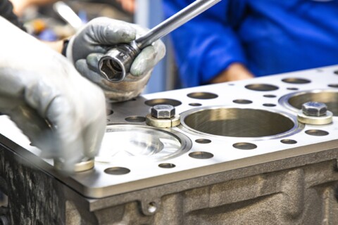 Close-up procesu montáže válcových pouzder v motoru.