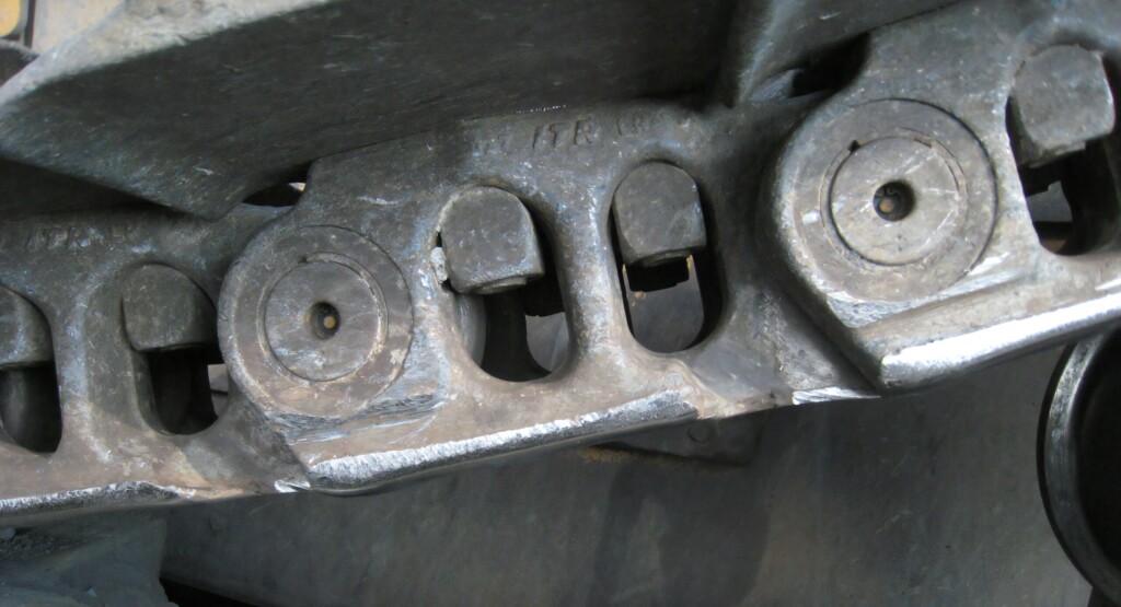 Detailní záběr na části pásového podvozku.