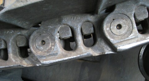 Detailní záběr na části pásového podvozku.